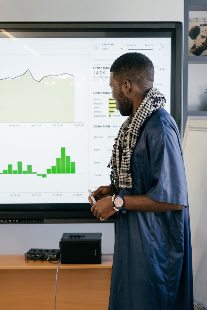 Professional analyzing graphs on a screen in an office. Business meeting concept.